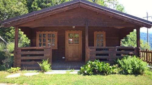 a log cabin with a porch and a wooden door at Campeggio Cianabie in Sampeyre
