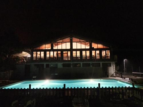 a building with a swimming pool at night at Campeggio Cianabie in Sampeyre