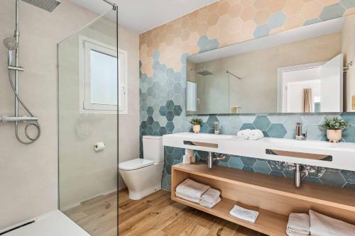 een badkamer met een wastafel, een toilet en een spiegel bij Villa Adriana Tomas in Santo Tomás