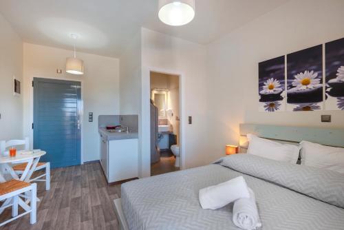 a bedroom with a bed and a table and a desk at Aegean Paradiso Vacation Club - "Adults Only" in Azolimnos