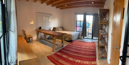 a room with a desk and a bed and a rug at Mesquite Tree Retreat in San Miguel de Allende