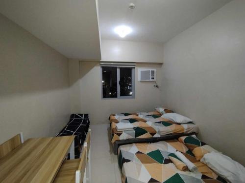 Zimmer mit 2 Betten und einem Tisch in der Unterkunft Sunvida Tower Across SM City Cebu in Cebu City