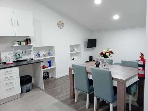 a kitchen with a table and blue chairs in a room at Apartment in Semeador in Portalegre