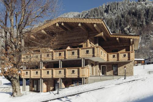 a large wooden house in the snow at Hotel Vermala in Sankt Gallenkirch