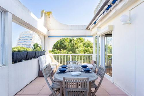 un patio avec une table et des chaises sur un balcon dans l'établissement Chez Muriel - Fabuleux appartement en centre ville avec parking, à La Grande Motte