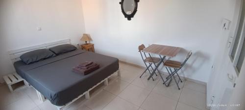 a small bedroom with a bed and a table at Óscar guest house in Mindelo