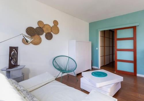 - un salon avec un canapé blanc et une chaise dans l'établissement Chez Muriel - Fabuleux appartement en centre ville avec parking, à La Grande Motte