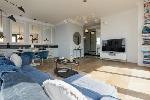 sala de estar con sofá azul y mesa en Royal Garden Apartment in Wilanow by Renters Prestige, en Varsovia