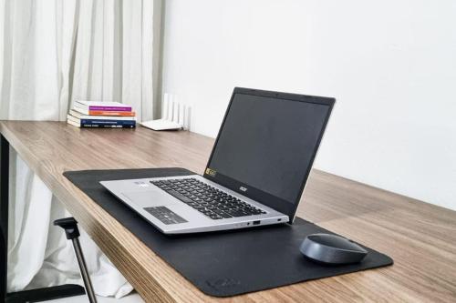 un ordenador portátil sentado en un escritorio con un ratón en Casa do Píer, en Governador Celso Ramos