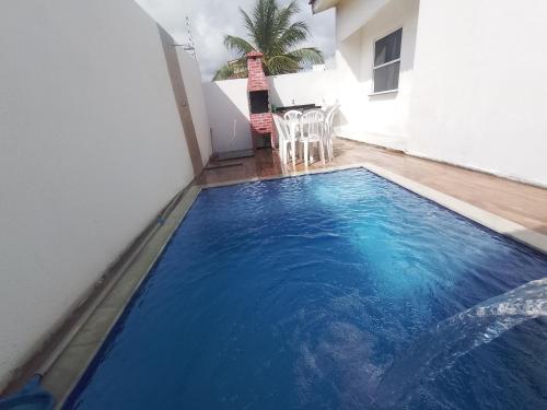 - une piscine bleue dans une pièce avec une table dans l'établissement Paraíso Praia Bela, à Pitimbu