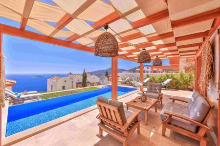 a house with a pool and a patio with chairs at Villa Blue, LaVanta, Kalkan in Kalkan