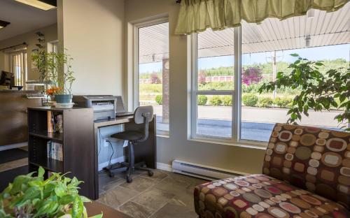 an office with a desk and a chair and windows at Bon Voyage Inn in Prince George