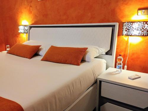 um quarto com uma cama com duas almofadas e uma mesa em Suleima B&B Messina Centro em Messina