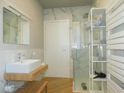 a bathroom with a sink and a glass shower at Casa Jotti in Cardano al Campo