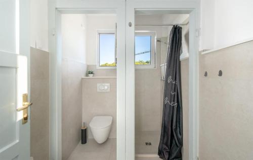 a bathroom with a toilet and a window at Awesome Home In Kolocep With Heated Swimming Pool in Koločep