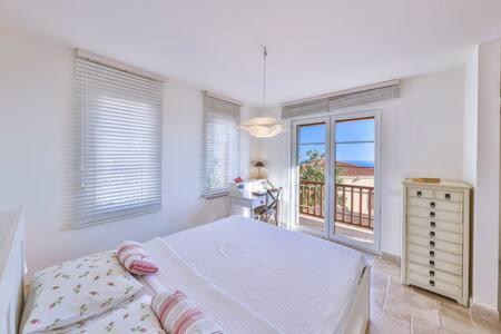 1 dormitorio con 1 cama grande y balcón en Villa Mavi, en Kalkan