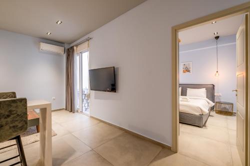 a bedroom with a bed and a tv on a wall at Sleek Plaka Retreat - Heart of Athens in Athens