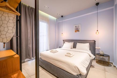 a bedroom with a large bed with white sheets at Sleek Plaka Retreat - Heart of Athens in Athens