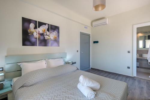 a bedroom with a bed with white sheets at Aegean Paradiso Vacation Club - "Adults Only" in Azolimnos