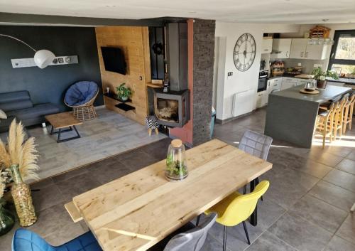 uma cozinha e uma sala de estar com uma mesa de madeira em Le haut du parc em Gérardmer