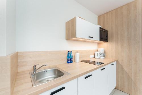a kitchen with a sink and a microwave at Bel Mare 407D in Międzyzdroje