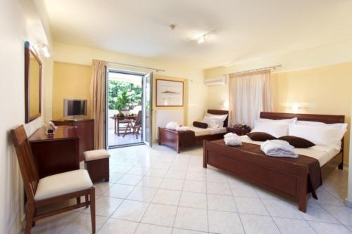 a bedroom with two beds and a couch and a chair at Belle View Hotel - Sea View & Sunset in Mánganos