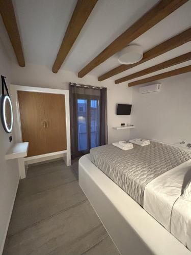 a white bedroom with a bed and a window at SOPHILIA SUITES in Koufonisia