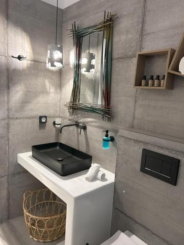 baño con lavabo negro y espejo en SOPHILIA SUITES, en Koufonisia