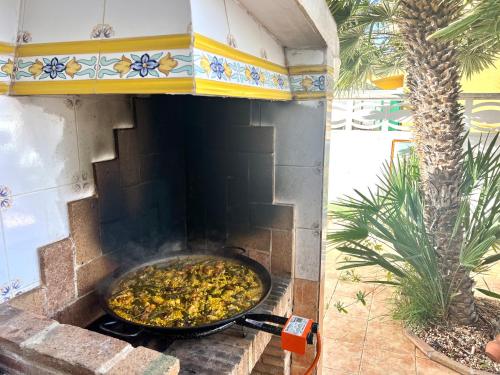 a large pan of food cooking in an outdoor oven at La Villa in Benicàssim
