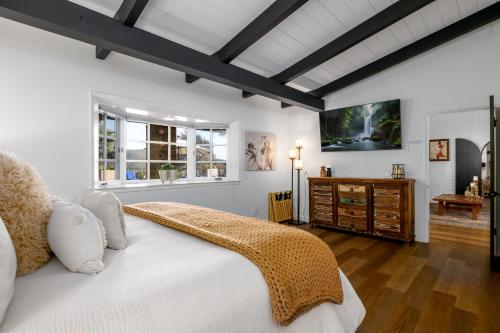 H1 California Adobe Estate at Moonlight Ranch, Views, Private, Heated pool, Jacuzzi, Petting zoo! في فيستا: غرفة نوم مع سرير وتلفزيون على الحائط