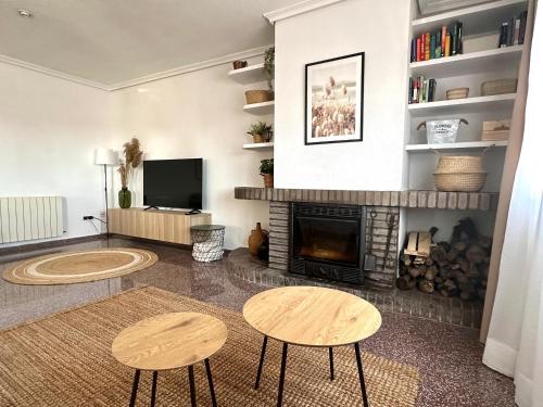 a living room with two tables and a fireplace at La Villa in Benicàssim