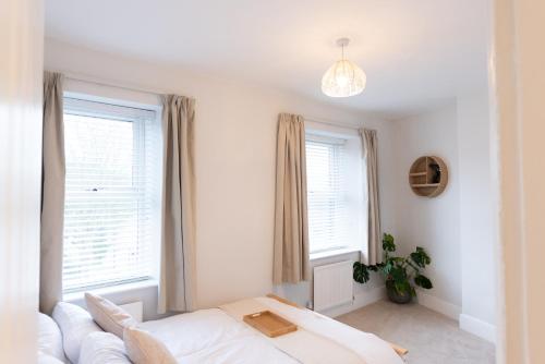 een slaapkamer met een bed en twee ramen bij Oak Cottage in Deepcar