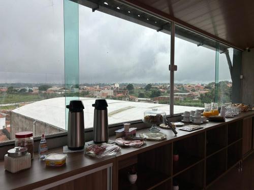 a counter with food on it with a large window at Hotel Carvalho in Ibiapina