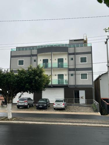 ein Gebäude mit drei Autos, die davor geparkt sind in der Unterkunft Hotel Carvalho in Ibiapina