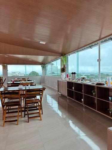 a dining room with wooden tables and a counter at Hotel Carvalho in Ibiapina