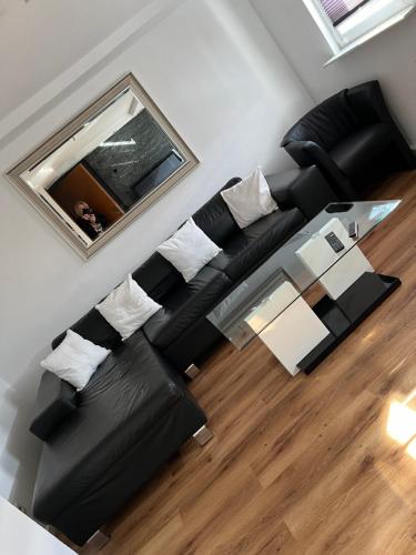 a living room with a black couch and a table at Ferienwohnung Eislingen in Eislingen