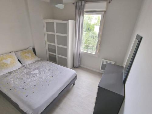 une chambre blanche avec un lit et une fenêtre dans l'établissement Apartment at only a few steps from Stade de France and 10 min from RER-B, à Saint-Denis