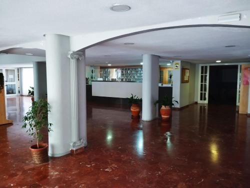 an empty lobby with white columns and potted plants at Apartamento Aguila in Benalmádena