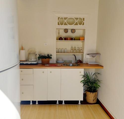 a kitchen with white cabinets and a sink at Christina's Stone House Apartment in Hydra