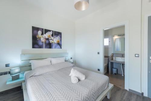 a bedroom with a white bed with two towels on it at Aegean Paradiso Vacation Club - "Adults Only" in Azolimnos