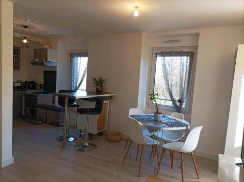 una cucina e una sala da pranzo con tavolo e sedie di Panoramique floral a La Gacilly