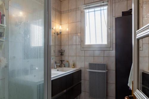 une salle de bain avec un lavabo et une douche en verre dans l'établissement Maison lumineuse quartier calme la barre de monts, à La Barre-de-Monts
