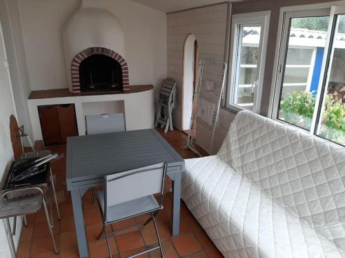 Cette chambre comprend un lit, une table et une cheminée. dans l'établissement Maison lumineuse quartier calme la barre de monts, à La Barre-de-Monts