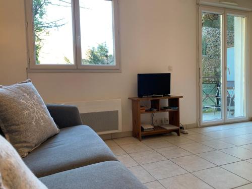 un salon avec un canapé et une télévision dans l'établissement Studio 2* pour 2 avec balcon, WiFi, animaux admis - FR-1-512-118, à Brides-les-Bains