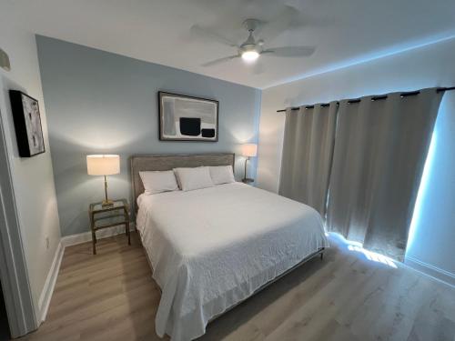 a bedroom with a white bed and a window at #1807 Big Heated Pool, Sunrise, Lake, Disney views in Orlando