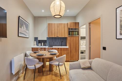 une cuisine et un salon avec une table et des chaises dans l'établissement Residence Center of Paris by Studio prestige, à Paris