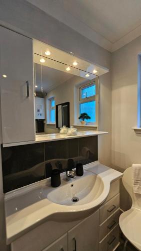 a bathroom with a sink and a mirror at Ards House Self catering apartment with sea views in Oban
