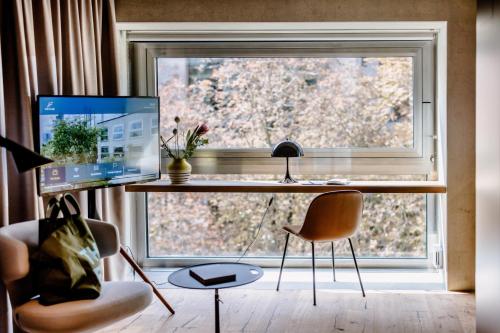 a desk with a computer in front of a window at THE FLAG West M. in Frankfurt/Main