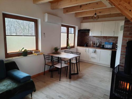 a kitchen and living room with a table and chairs at Domki Nad Potokiem in Rytro