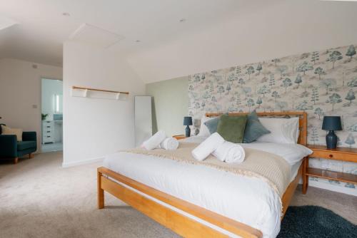 1 dormitorio con 1 cama grande con sábanas y almohadas blancas en Old Stable Cottage, en Stoborough